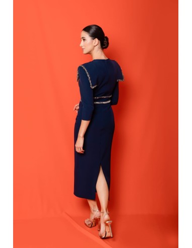 Vestido midi ajustado con pasamanería en hombros y cintura. Forro interior. Cierre mediante cremallera trasera.