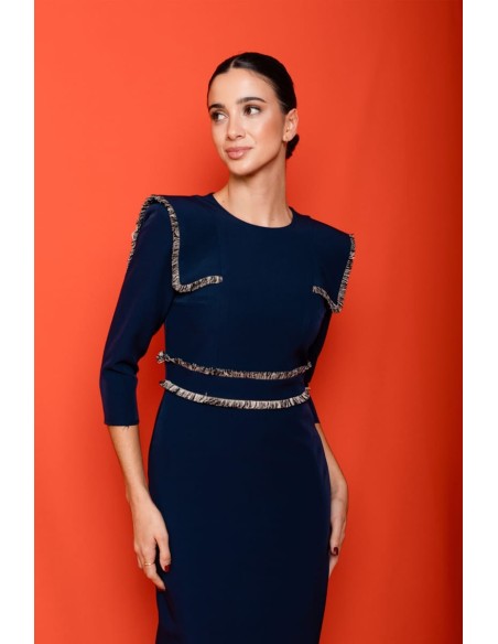 Vestido midi ajustado con pasamanería en hombros y cintura. Forro interior. Cierre mediante cremallera trasera.