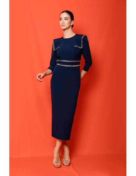 Vestido midi ajustado con pasamanería en hombros y cintura. Forro interior. Cierre mediante cremallera trasera.