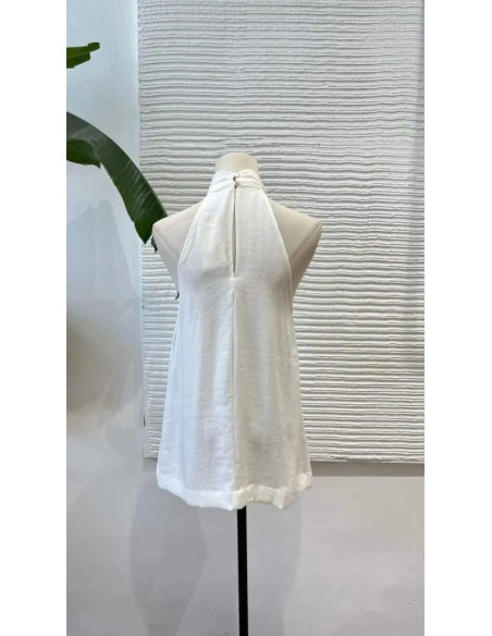 Camisa en sisa con cuello halter de lino y detalle argolla metalizada. Cierre mediante botón trasero.