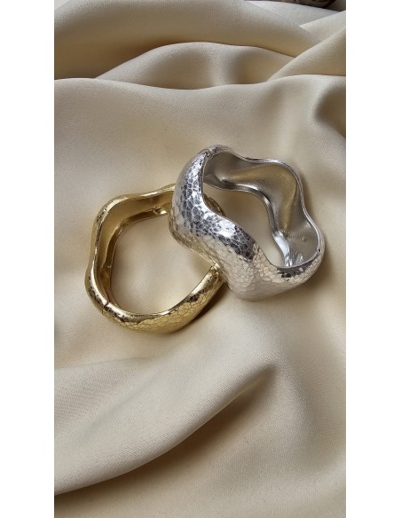 Brazalete metalizado con forma ondulada. Cierre con muelle.