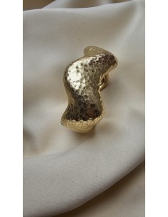 Brazalete metalizado con forma ondulada. Cierre con muelle.