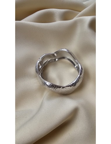 Brazalete metalizado con forma ondulada. Cierre con muelle.