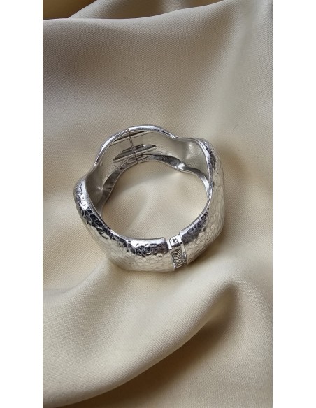 Brazalete metalizado con forma ondulada. Cierre con muelle.
