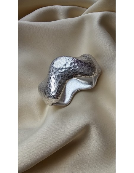 Brazalete metalizado con forma ondulada. Cierre con muelle.