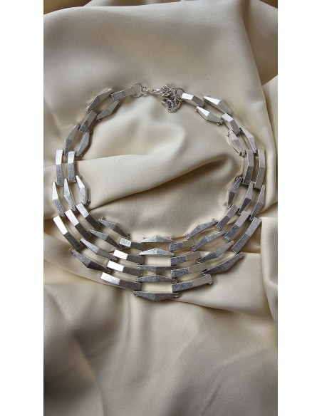 Collar metalizado con formas asimétricas. Cierre con codena y presilla.