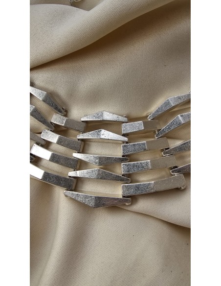 Collar metalizado con formas asimétricas. Cierre con codena y presilla.