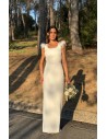 Vestido largo recto con tejido fluido y espalda al aire. Detalle de pedrería y plumas en el hombro. Cierre mediante botones forr