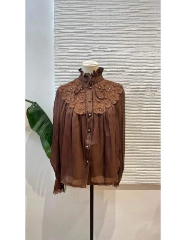 Camisa de manga larga en tejido fluido con detalle de flores bordadas en escote y puños. Cierre mediante botones nacarados y laz