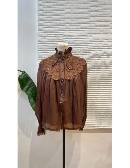 Camisa de manga larga en tejido fluido con detalle de flores bordadas en escote y puños. Cierre mediante botones nacarados y laz