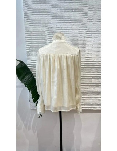 Camisa de manga larga en tejido fluido con detalle de flores bordadas en escote y puños. Cierre mediante botones nacarados y laz