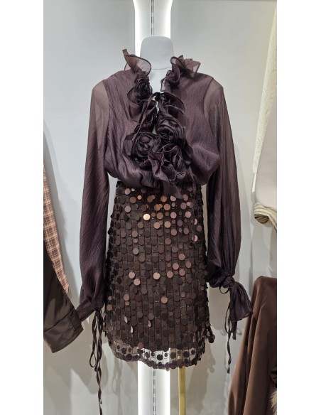 Camisa con manga farol y puño fruncido con lazada. Detalle de cuello chorreras y flores en el mismo tejido.