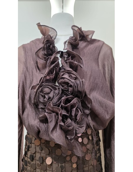 Camisa con manga farol y puño fruncido con lazada. Detalle de cuello chorreras y flores en el mismo tejido.