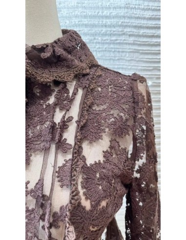 Corpiño peplum en encaje de manga larga con cuello. Cierre mediante botones delanteros. Tejido algo elástico.