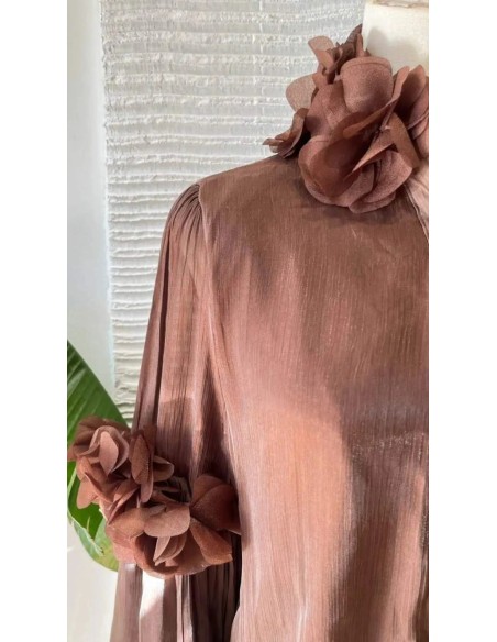Camisa con manga farol y detalle de pétalos en manga y cuello. Cierre mediante botones frontales.