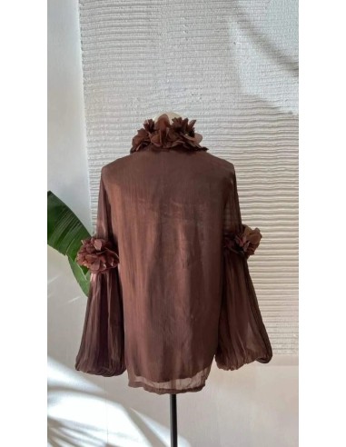 Camisa con manga farol y detalle de pétalos en manga y cuello. Cierre mediante botones frontales.