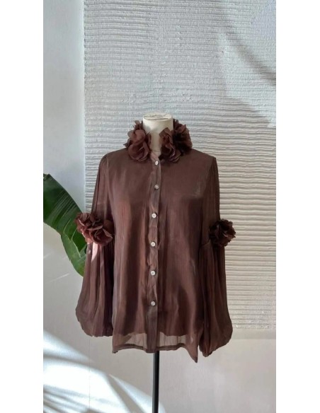 Camisa con manga farol y detalle de pétalos en manga y cuello. Cierre mediante botones frontales.