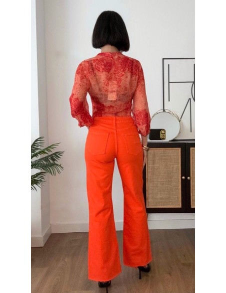 Top estampado en georgette con detalle de nudo. Cierre con botón en el cuello delantero.