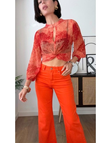 Top estampado en georgette con detalle de nudo. Cierre con botón en el cuello delantero.