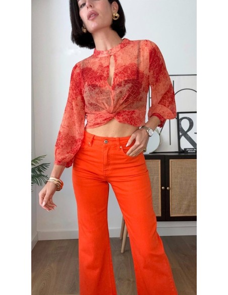 Top estampado en georgette con detalle de nudo. Cierre con botón en el cuello delantero.
