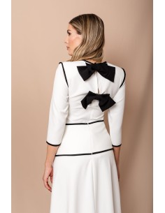 Conjunto compuesto por top con detalle de vivos y lazos en la espalda y falda evasé con detalles de vivos y 7 botones de bola.