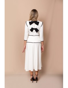 Conjunto compuesto por top con detalle de vivos y lazos en la espalda y falda evasé con detalles de vivos y 7 botones de bola. 2