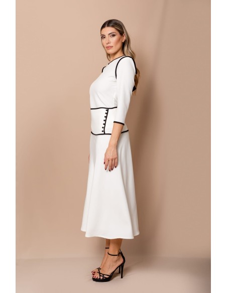 Conjunto compuesto por top con detalle de vivos y lazos en la espalda y falda evasé con detalles de vivos y 7 botones de bola.