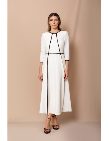 Vestido de corte midi en crepe elástico blanco y negro. Es de corte evasé, tiene cuello a la caja y mangas tres cuartos.