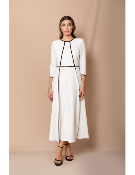 Vestido de corte midi en crepe elástico blanco y negro. Es de corte evasé, tiene cuello a la caja y mangas tres cuartos.