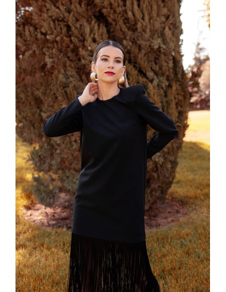 Vestido básico con flecos largo en el bajo y maxi hombrera. Cierre mediante cremallera invisible trasera.
