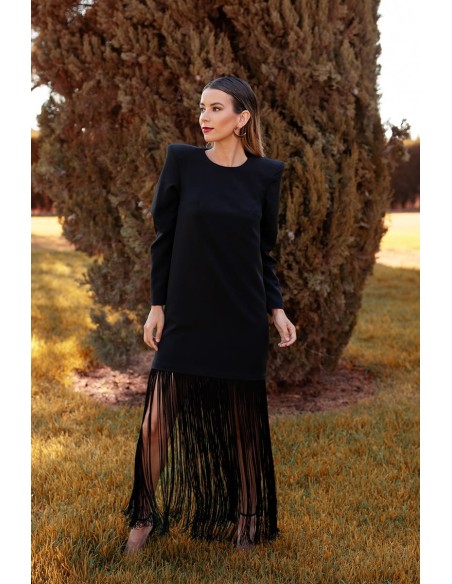 Vestido básico con flecos largo en el bajo y maxi hombrera. Cierre mediante cremallera invisible trasera.